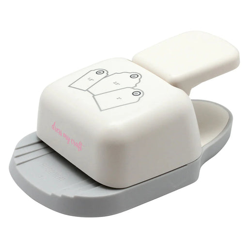 An isometric view of the cream and gray Dress My Craft 3-in-1 Rounded Tag Punch, showing the tag-size alignment guides on the base and the ergonomic press lever.